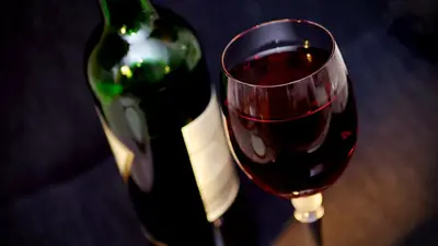 A bottle and a glass of red wine