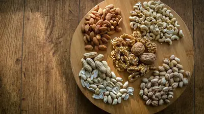 A board with assorted nuts such as walnuts, almonds and pistachios