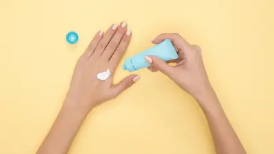 Hands applying moisturizing cream