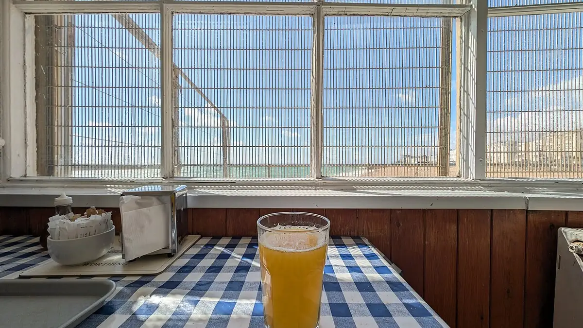 A glass of orange juice on a checkered tablecloth