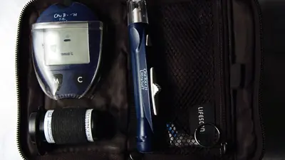 A blood glucose meter kit with lancing device and test strips in its case